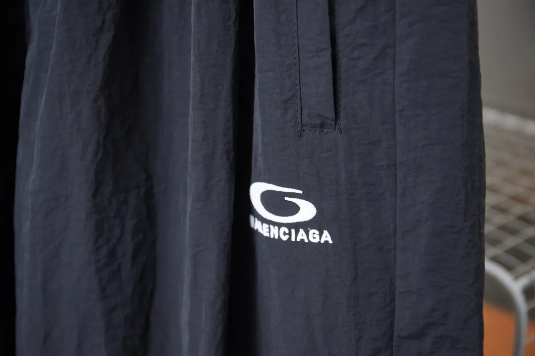 Balenciaga 𝘽𝘼𝙇𝙀𝙉𝘾𝙄𝘼𝙂𝘼 BLCG 26SS 71 front and rear half-circle letter embroidered sports suit Light luxury essential item for daily commuting for men and women Correct version Welcome to compare Detailed features · Customized matt Taslan jacket fabric · The fabric has undergone a waterproof coating process · The interior is made of three-grade polyester bird's eye mesh · OS ultra-loose silhouette design · Side zipper pockets Small stand-up collar design · Internal zipper pocket design · Elastic waistband design at the hem · Customized molded hardware zippers Jacket double puller design · Tajima high-speed embroidery machine with 100,000-needle three-dimensional design · Double side pockets on trousers · Original main mark washed tag brand packaging Color: Black/Milk Apricot Size: 46/48/50/52